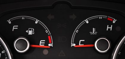 Detailed view of a car's fuel and temperature gauges on dashboard.