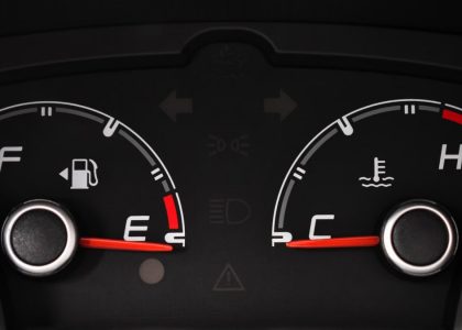 Detailed view of a car's fuel and temperature gauges on dashboard.